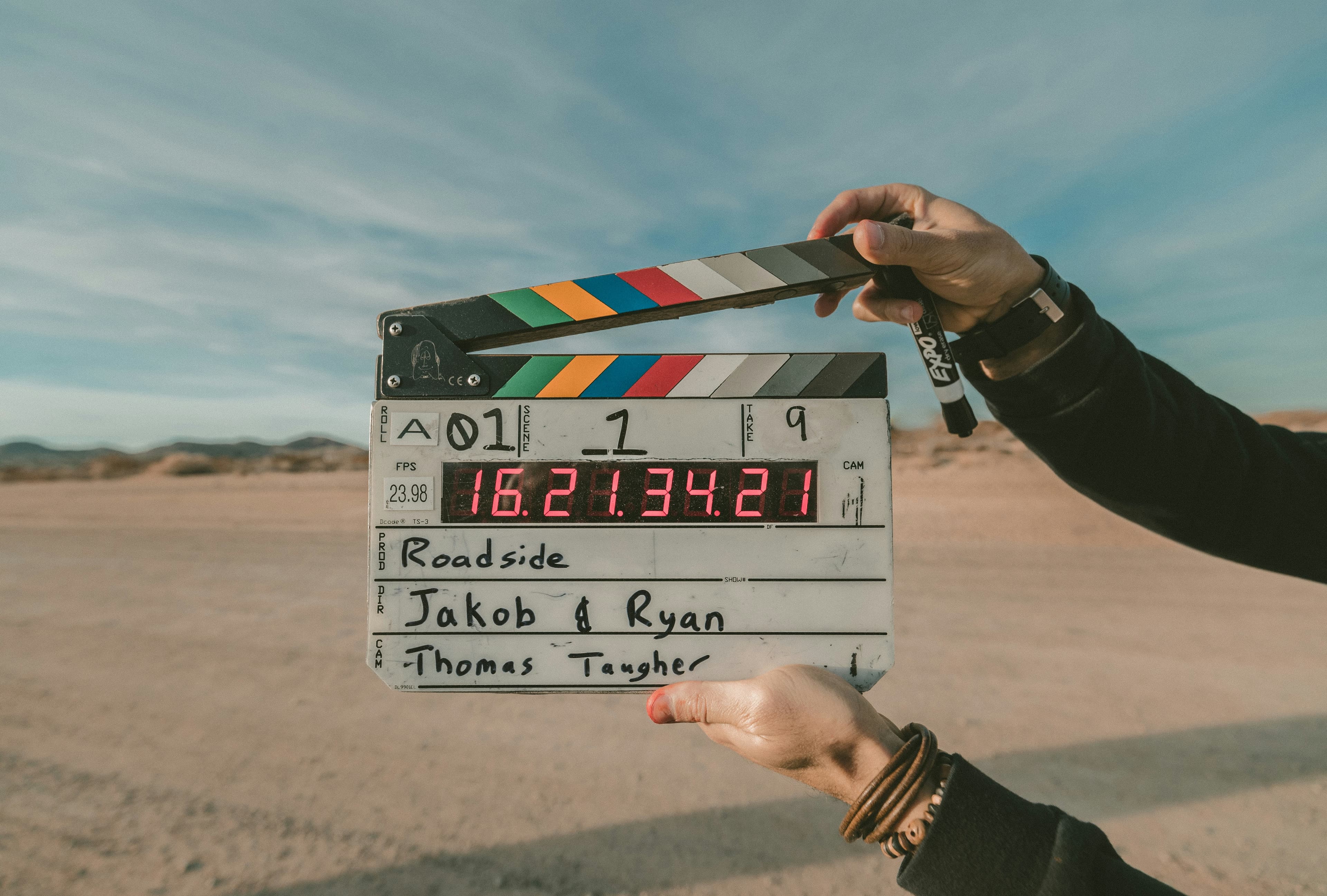A black and white film clapperboard held up outdoors before a take