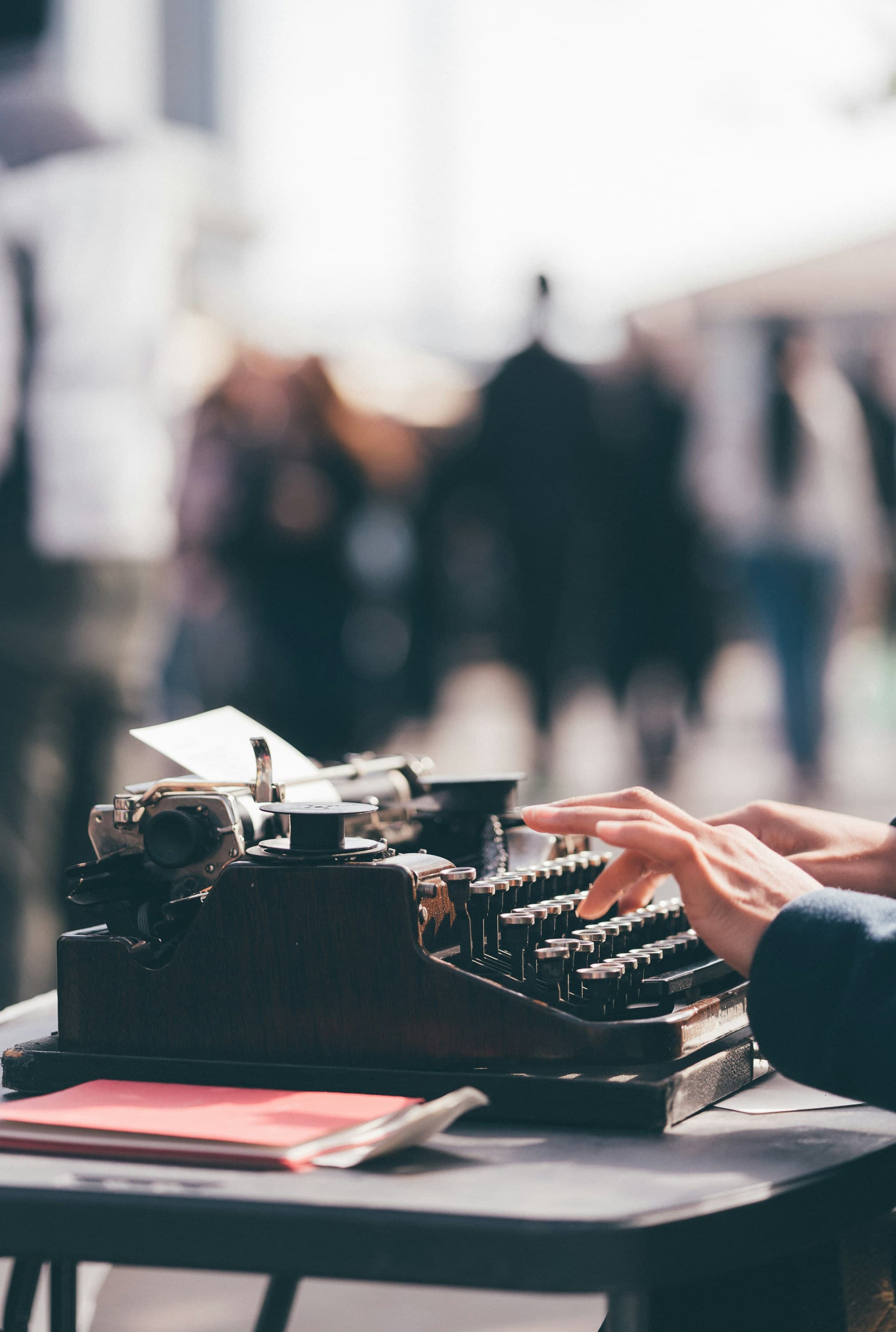 Person typing on a black manual typewriter