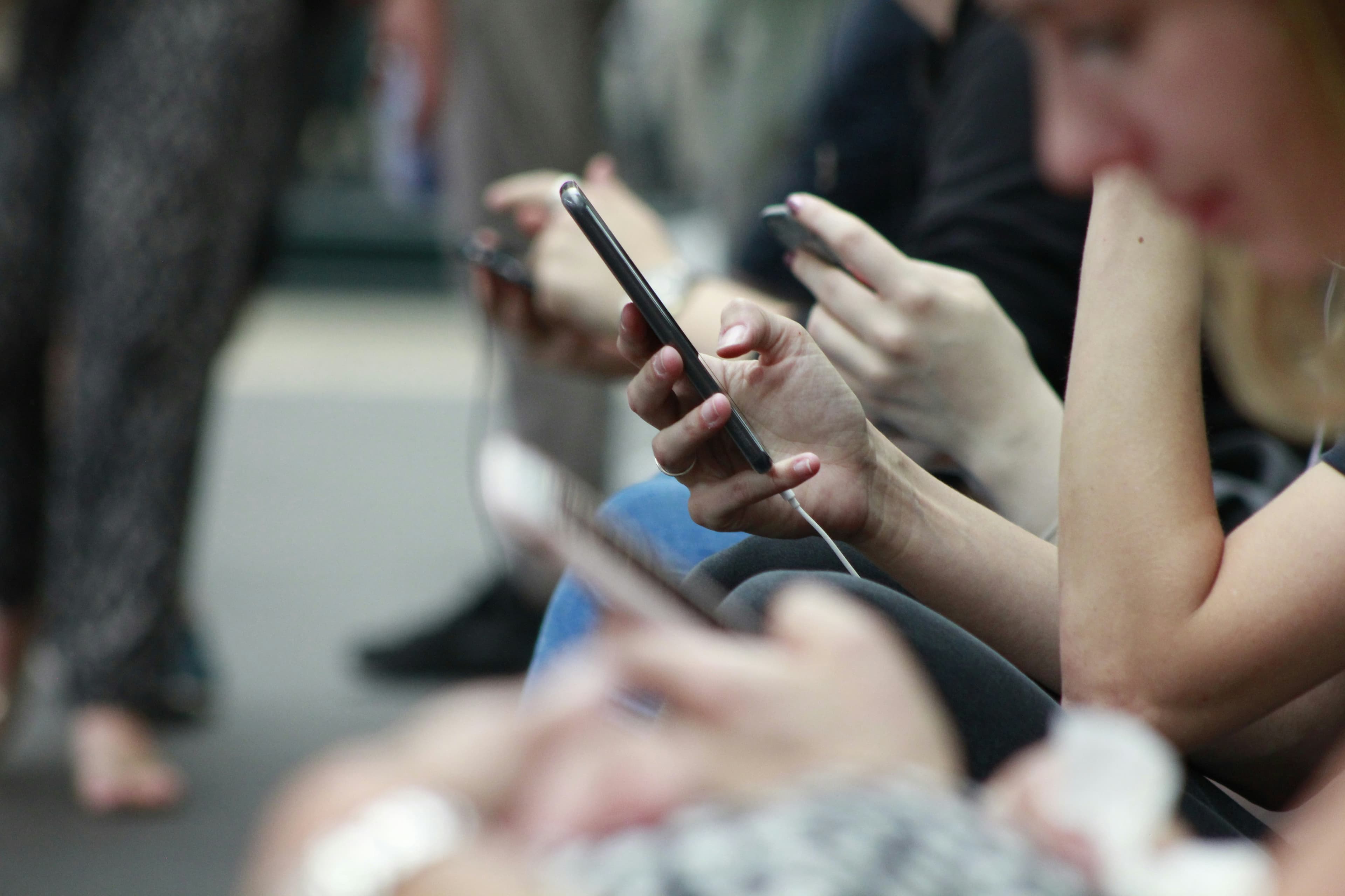 Person holding a phone, mid-scroll on a social feed