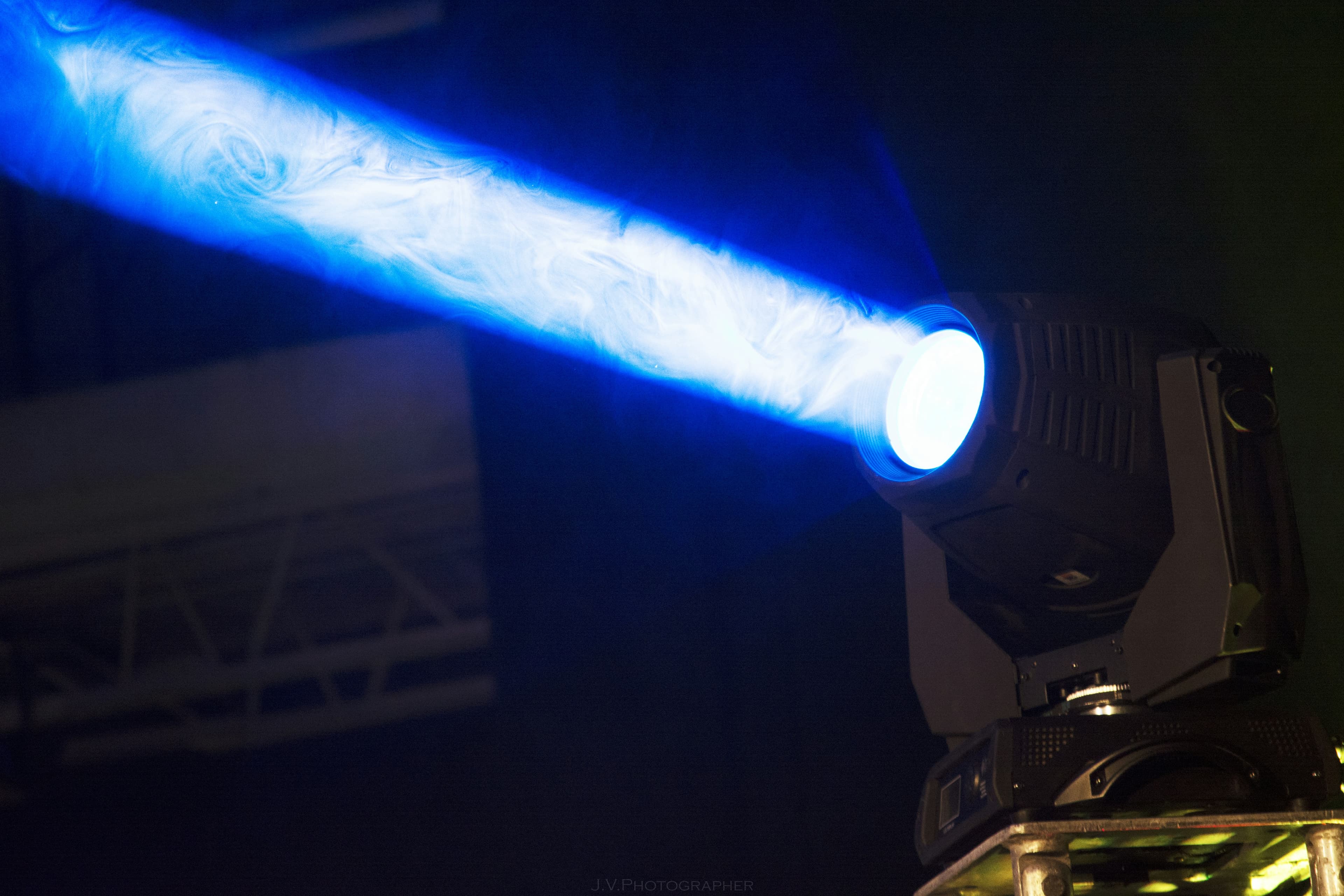 A single blue spotlight beam cutting through darkness