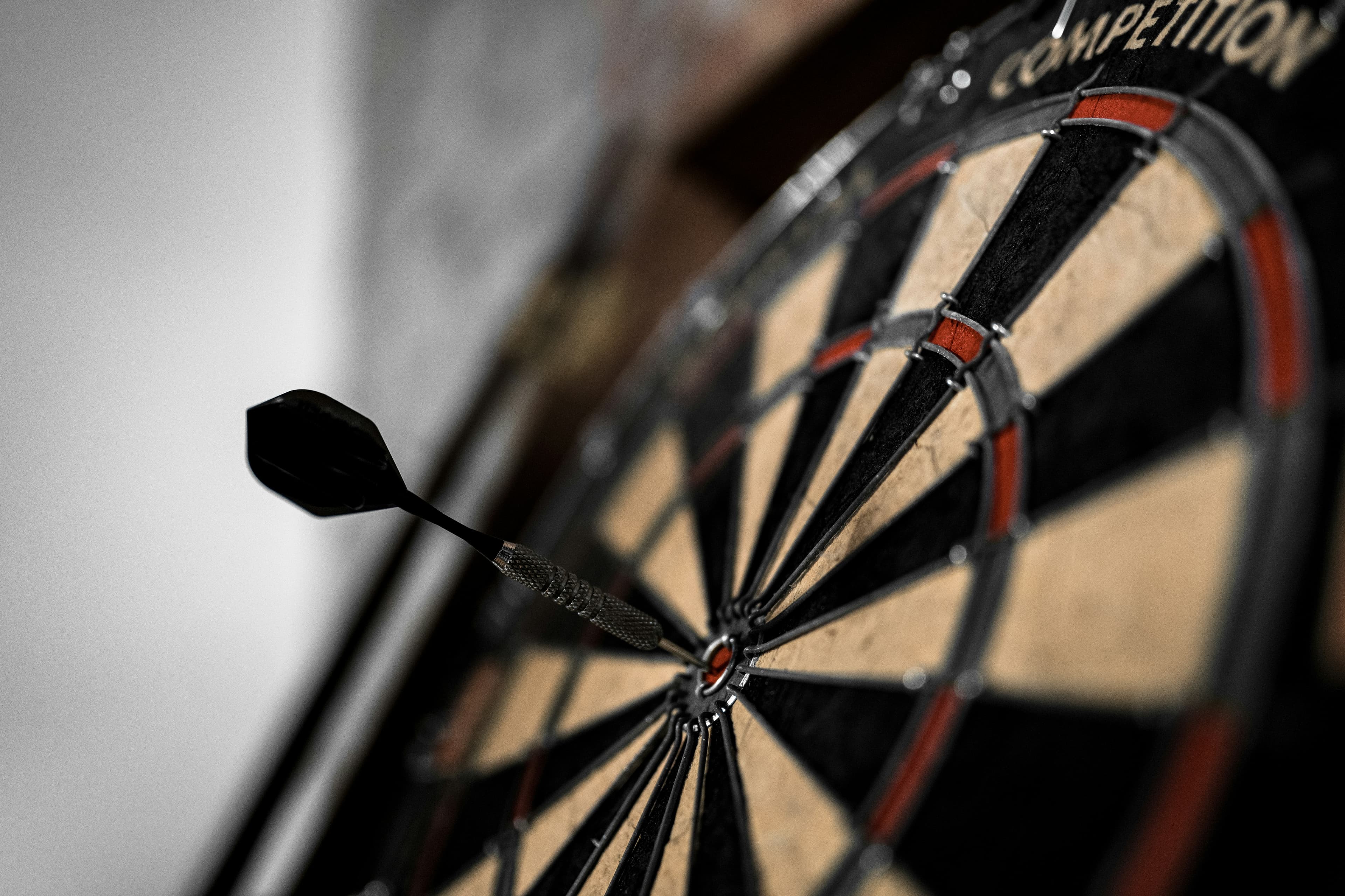 Close-up of a dartboard, attention drawn toward the bullseye